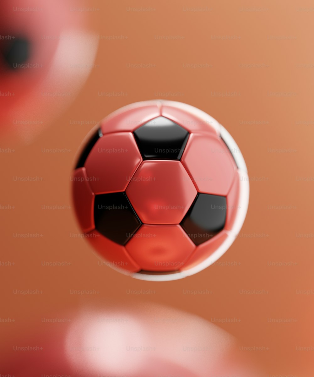 a red and black soccer ball flying through the air