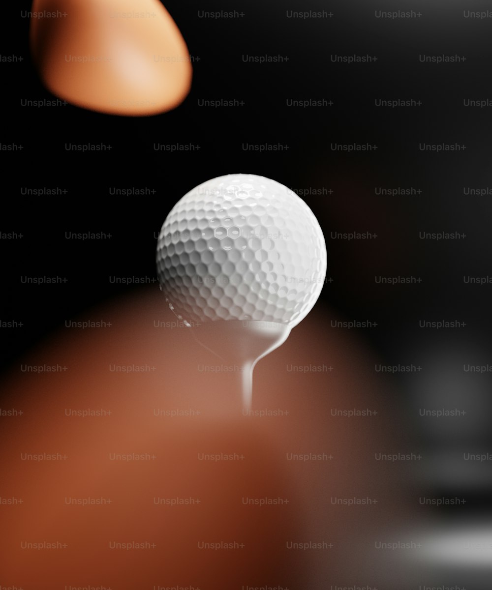 Una pelota de golf sentada encima de un tee