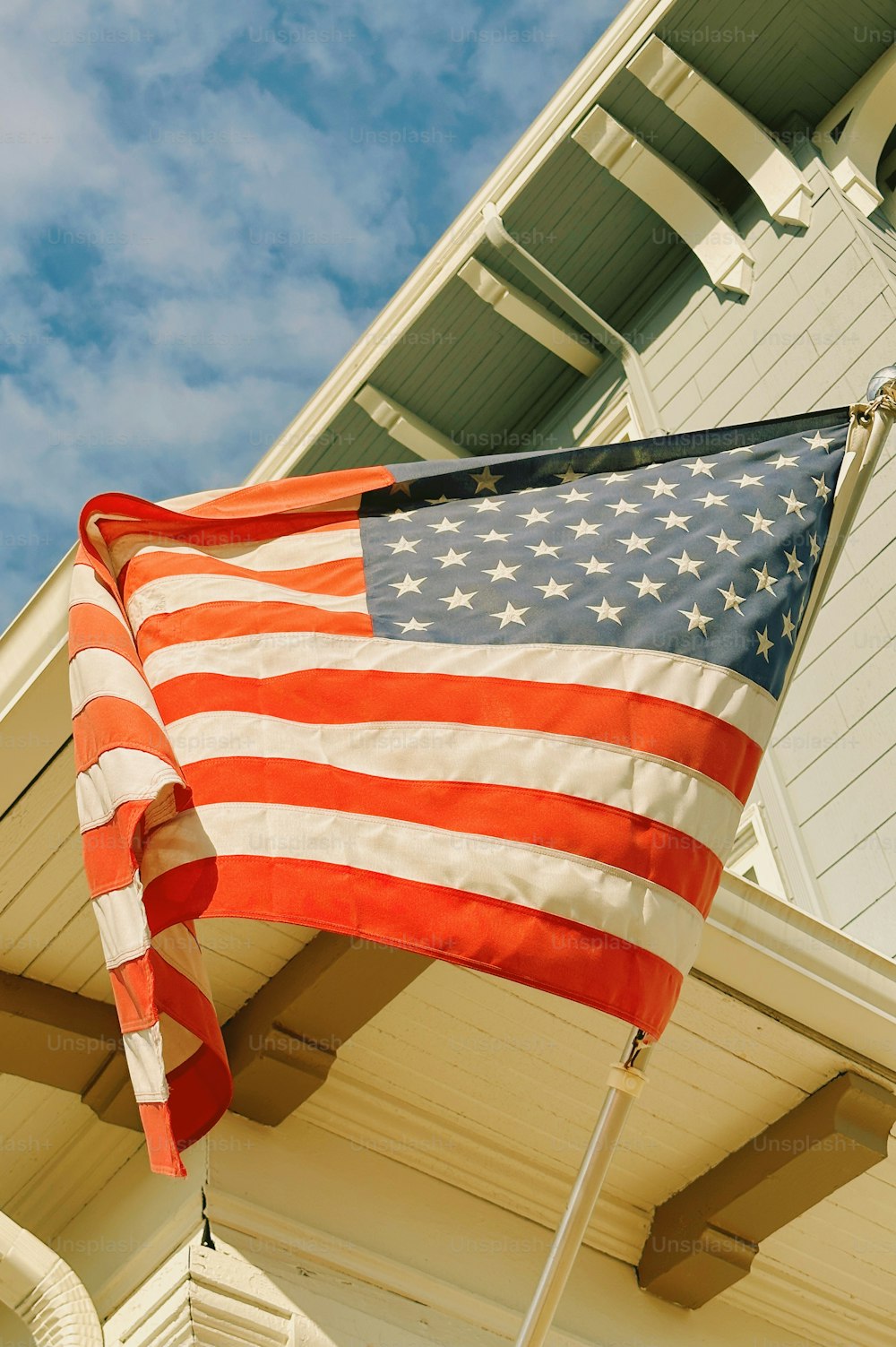 Una bandera estadounidense en un poste fuera de una casa
