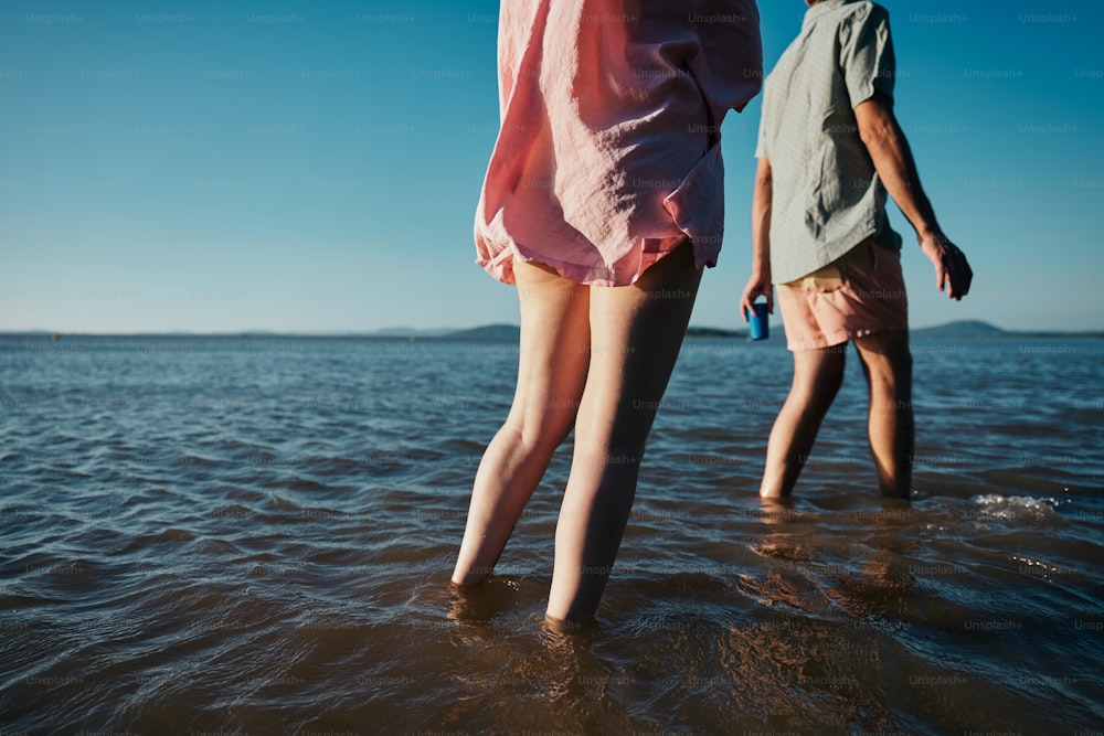um par de pessoas em pé em cima de um corpo de água