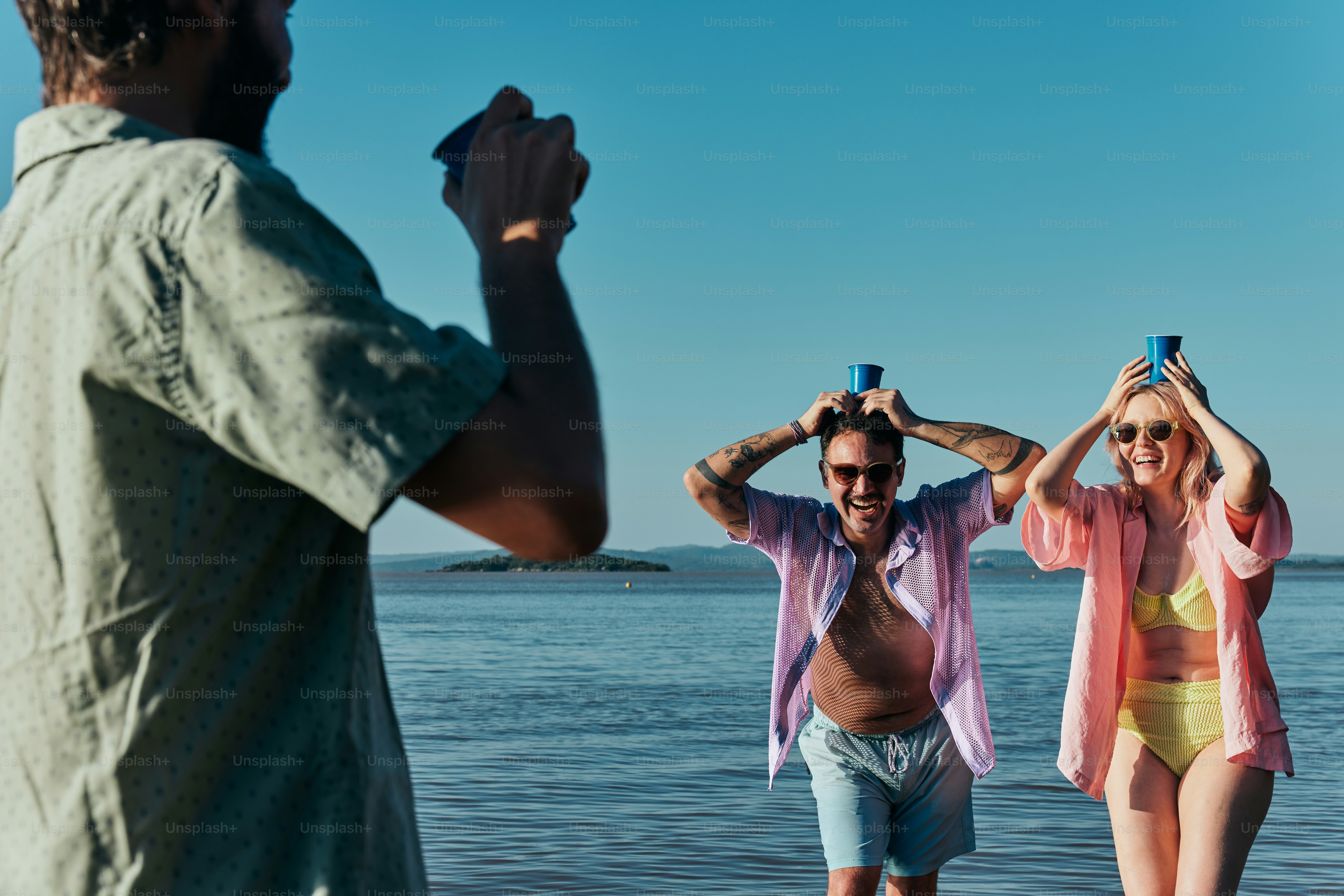 Ein Mann fotografiert zwei Frauen am Strand
