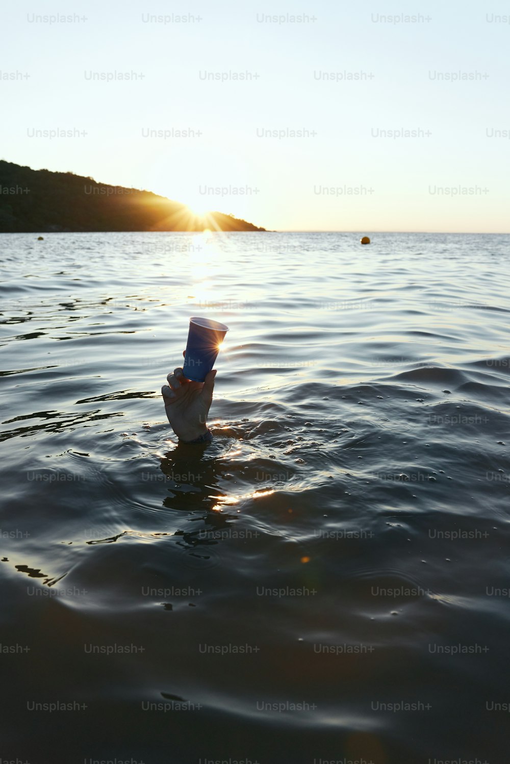 a plastic cup floating in the middle of a body of water