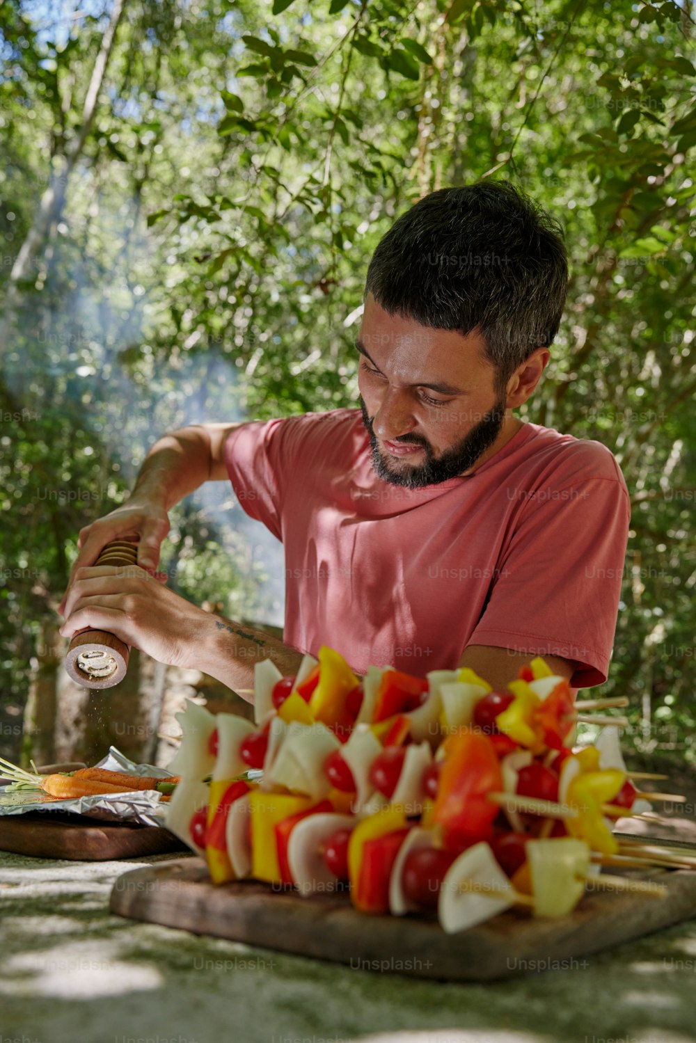 a man pouring a bottle of wine over a platter of fruit