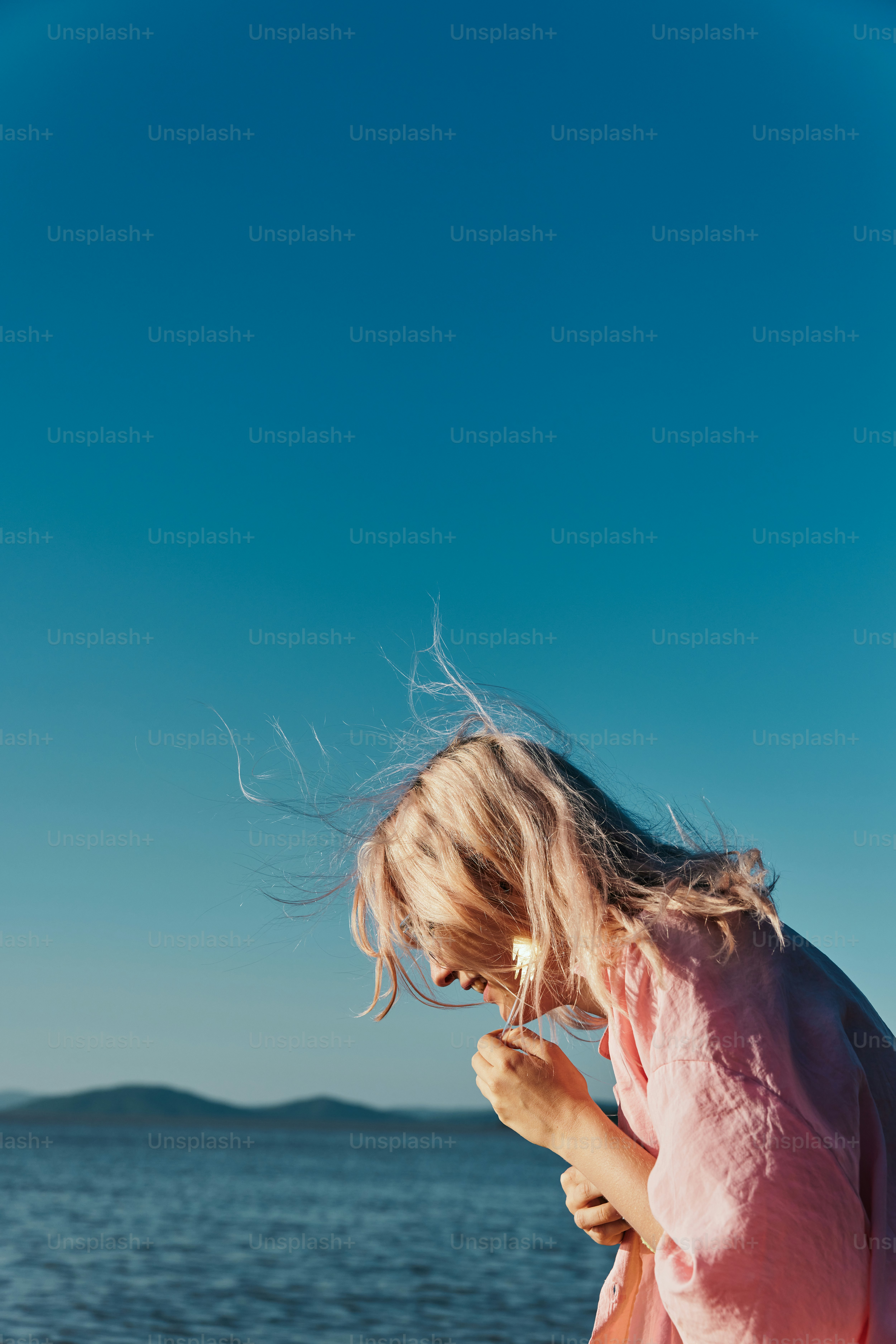 a little girl standing on a beach next to the ocean