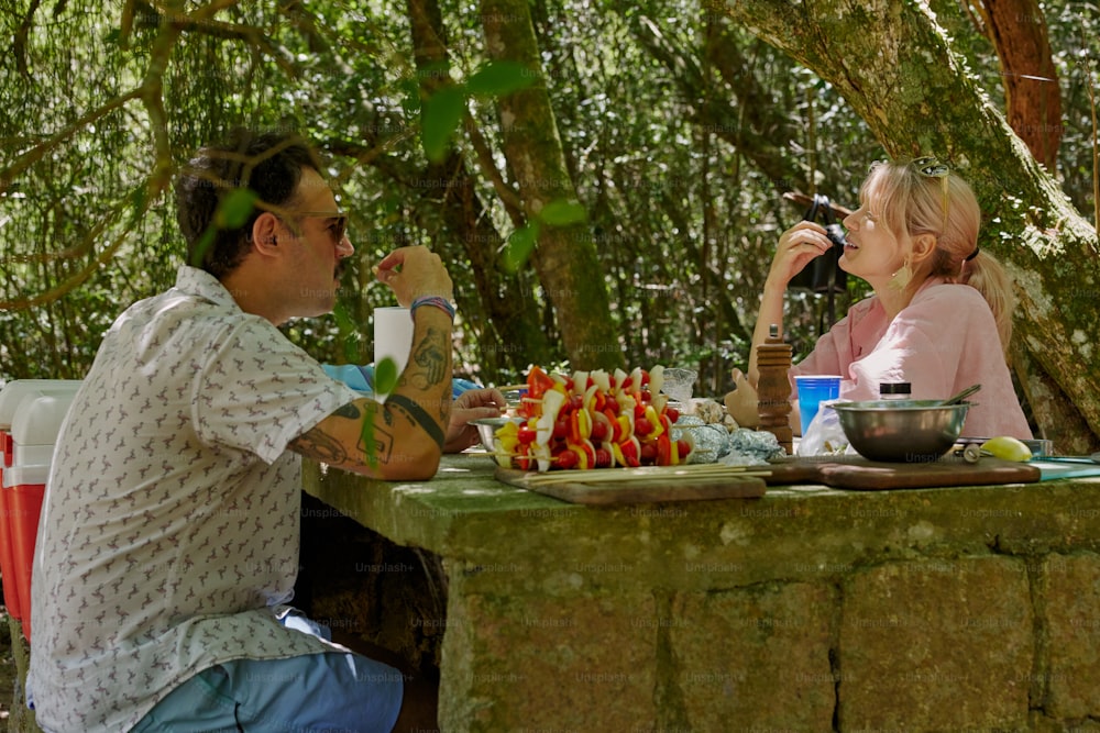 um homem e uma mulher sentados em uma mesa de piquenique