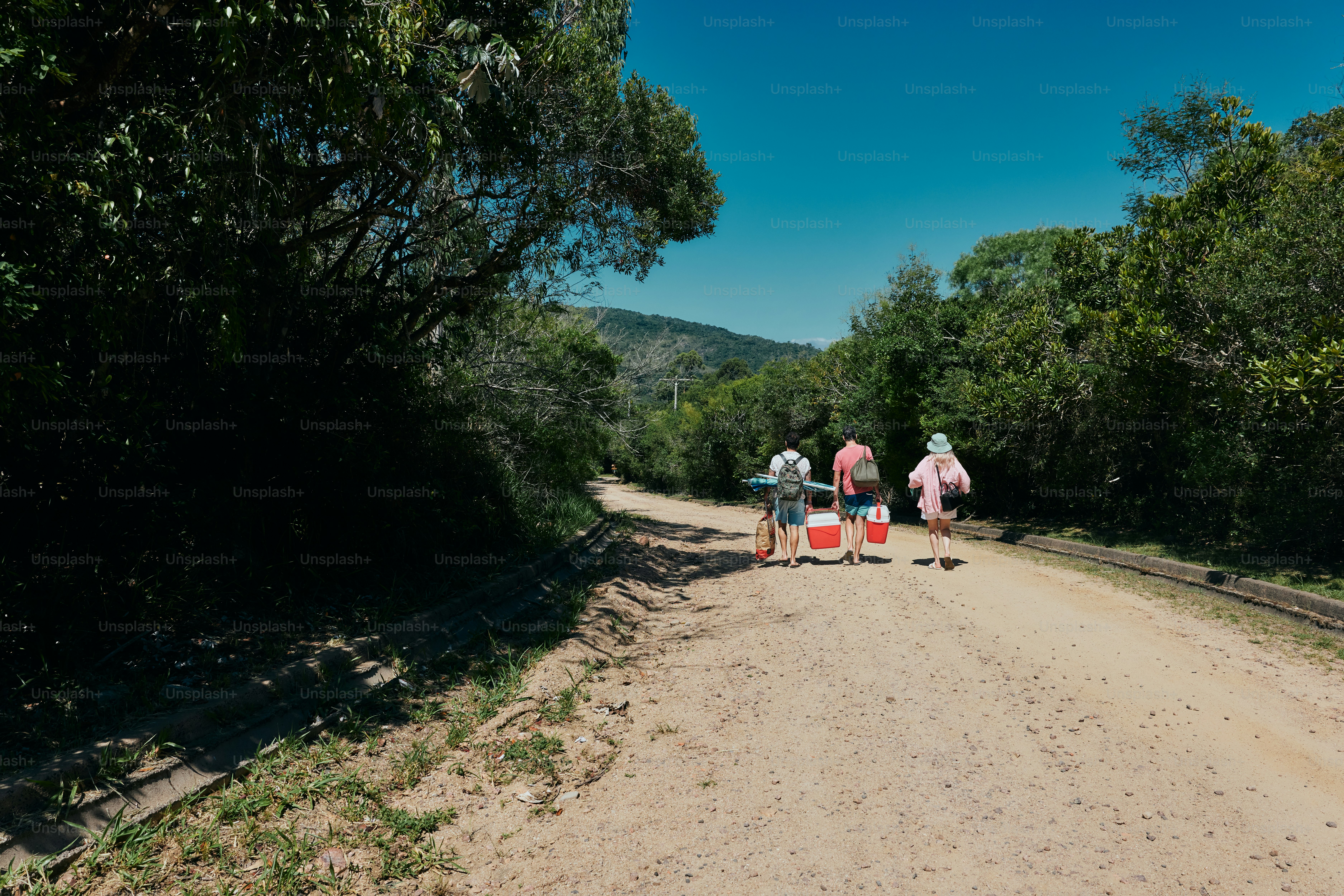 A group of people walking down a dirt road photo – Friends Image on ...