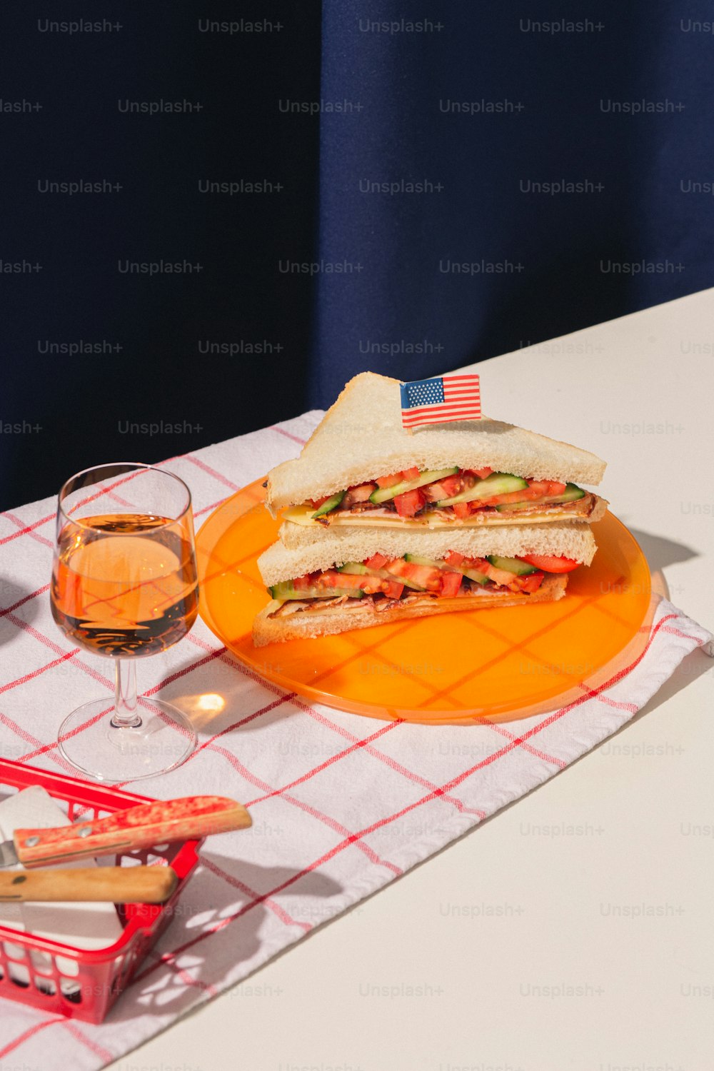 a plate with a sandwich and a glass of wine