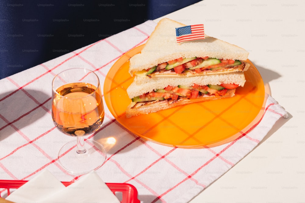 a plate with a sandwich and a glass of wine