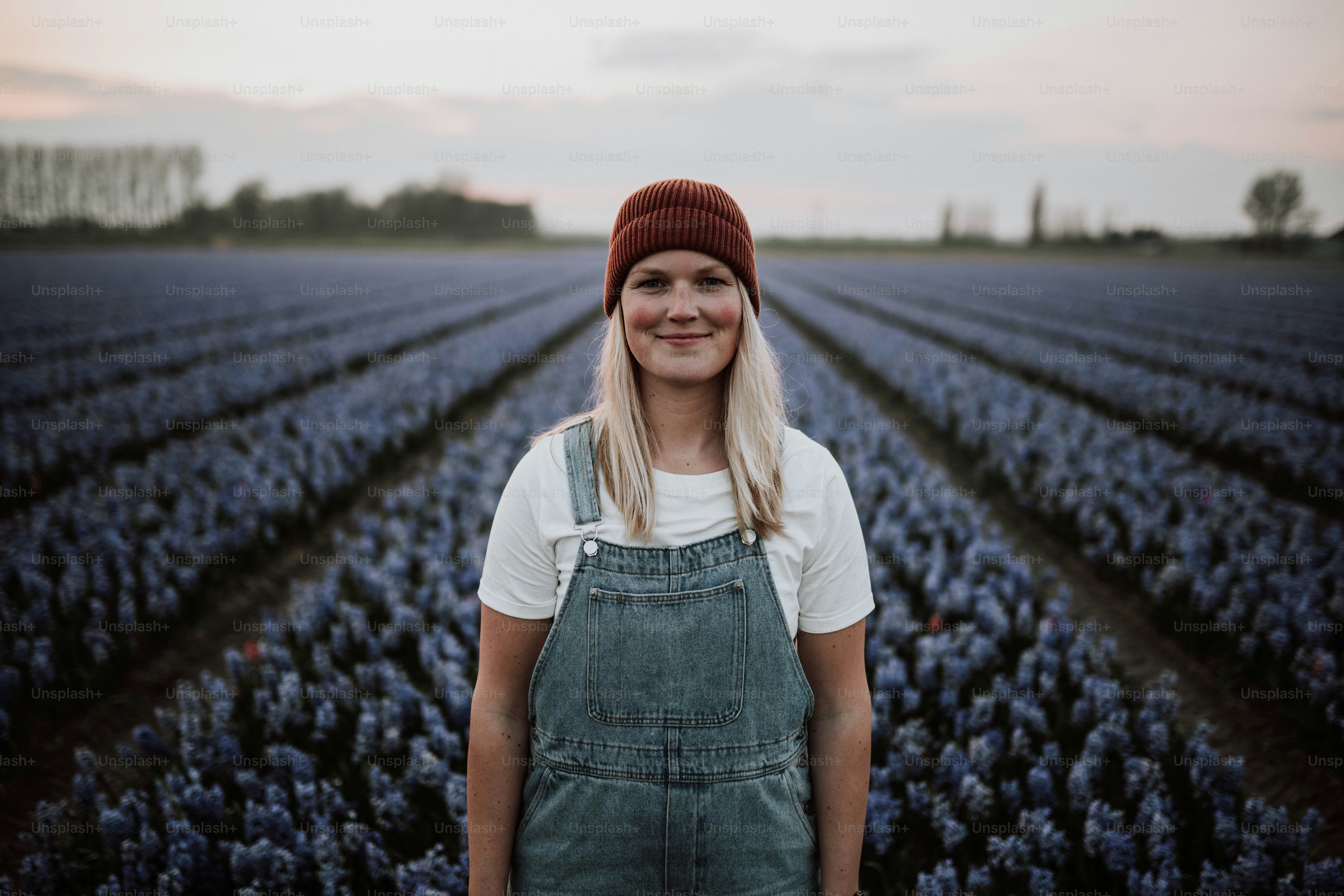 A woman standing in a field of blue flowers photo – Woman Image on Unsplash