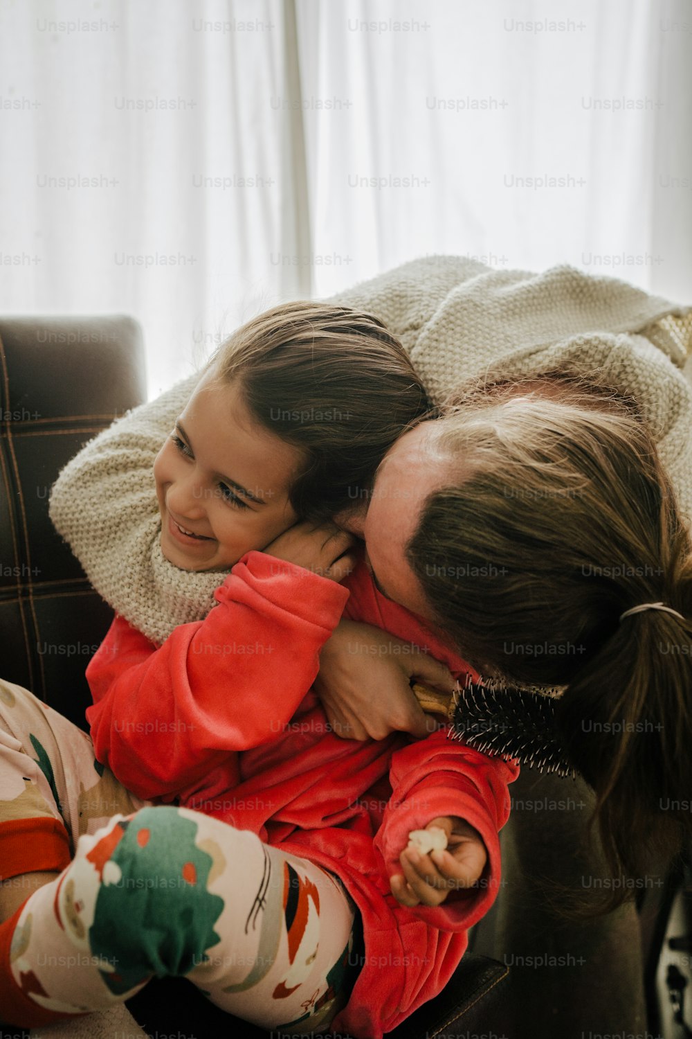 two young girls hugging each other on a couch