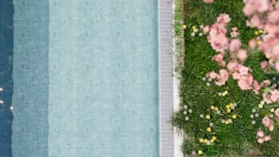 uma piscina com grama e flores ao lado