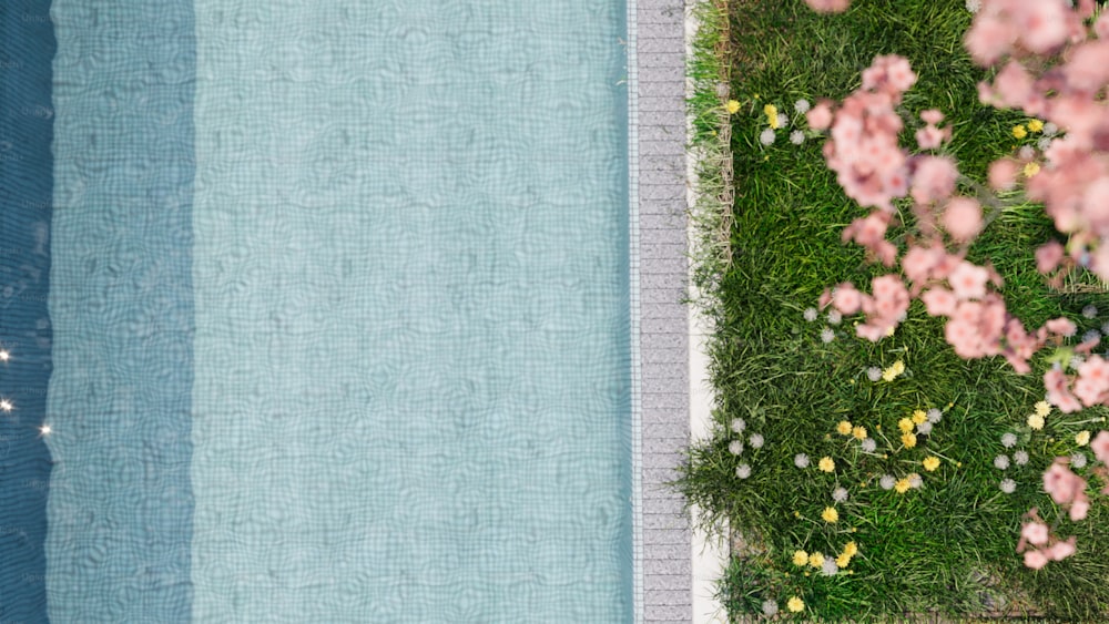 a pool with grass and flowers next to it