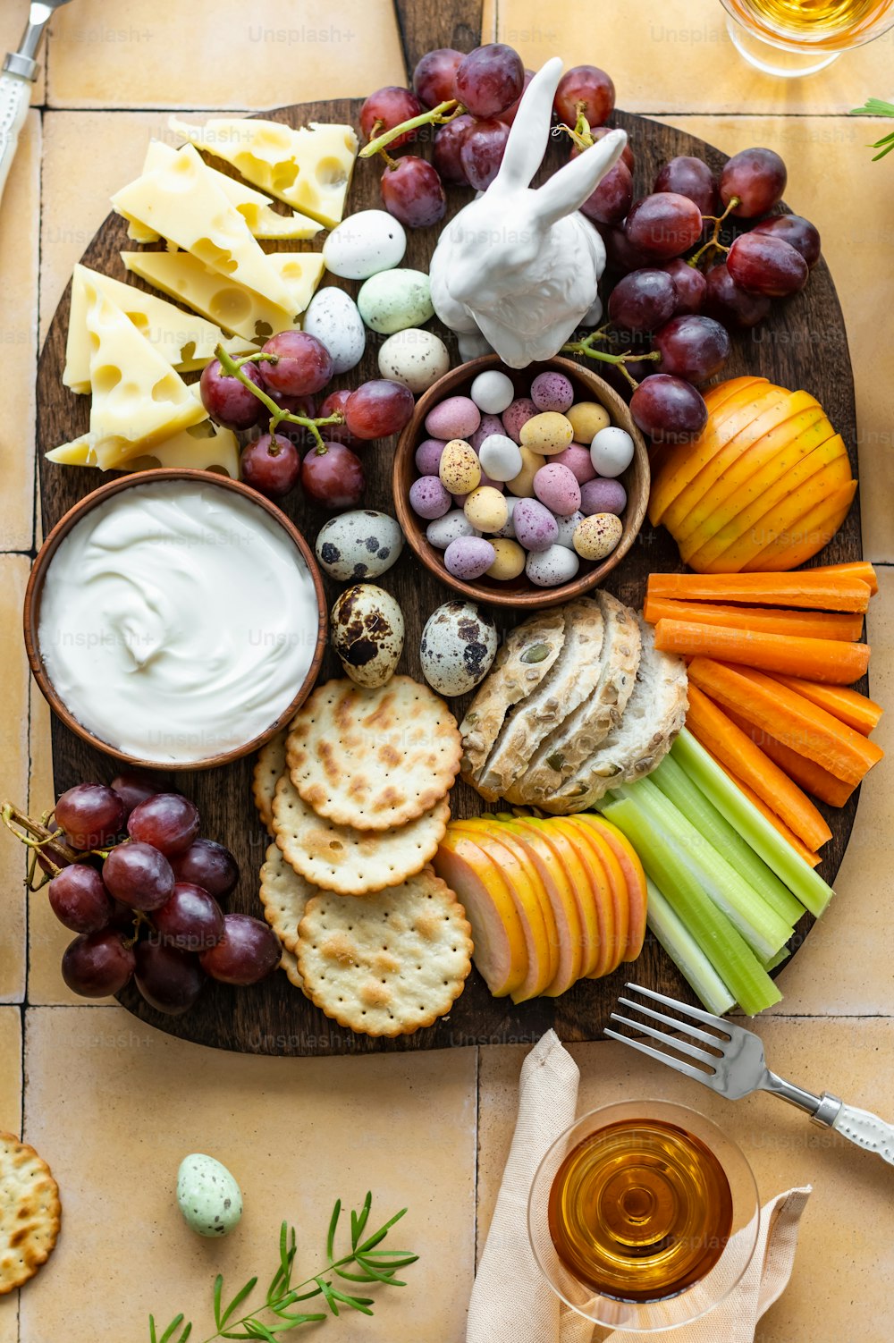 a platter of cheese, crackers, crackers, grapes, carrots