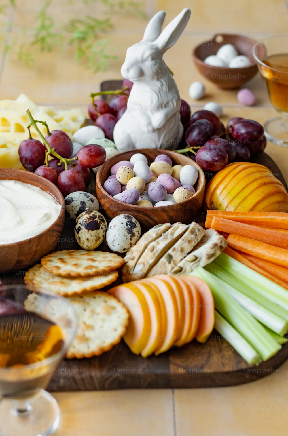 un plateau de fromage, de craquelins, de fruits et d’une figuri de lapin