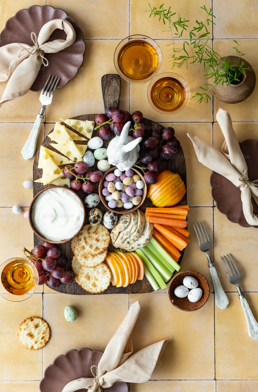 a platter of cheese, crackers, grapes, carrots, crackers