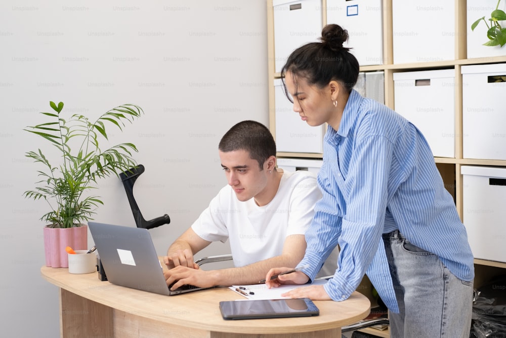Un homme et une femme travaillant sur un ordinateur portable