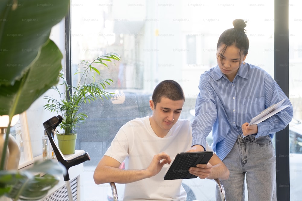 a man and a woman looking at a tablet