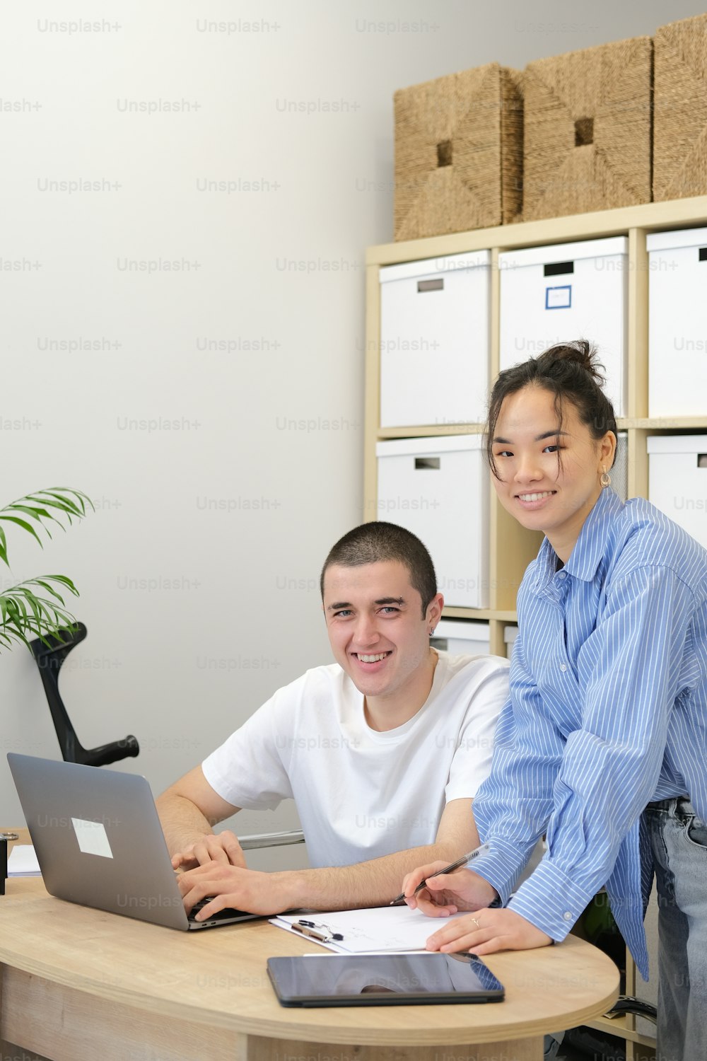 a man and a woman sitting at a table with a laptop