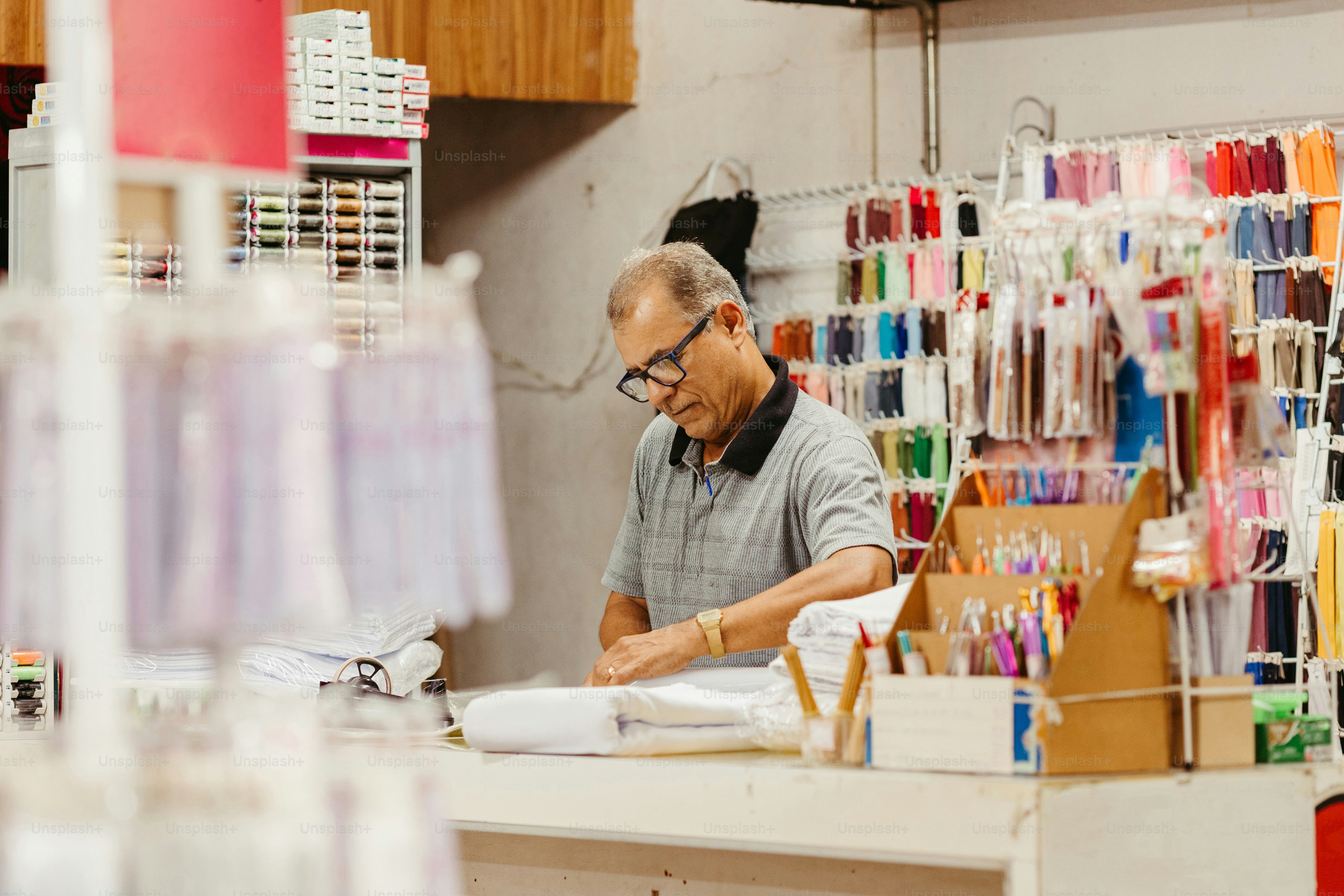 um homem trabalhando em um pedaço de papel em uma loja