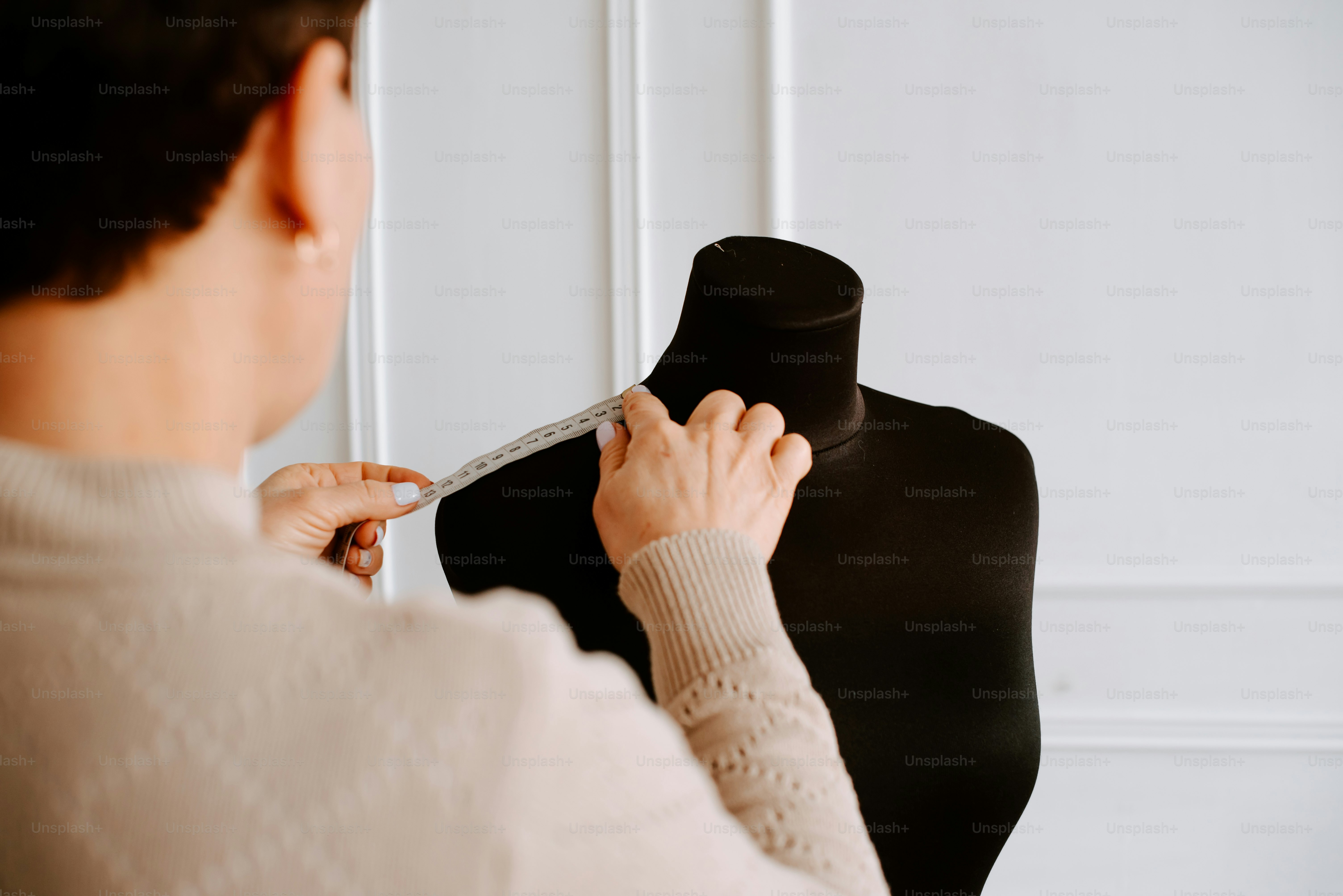 セーターを着たマネキンで作業する女性