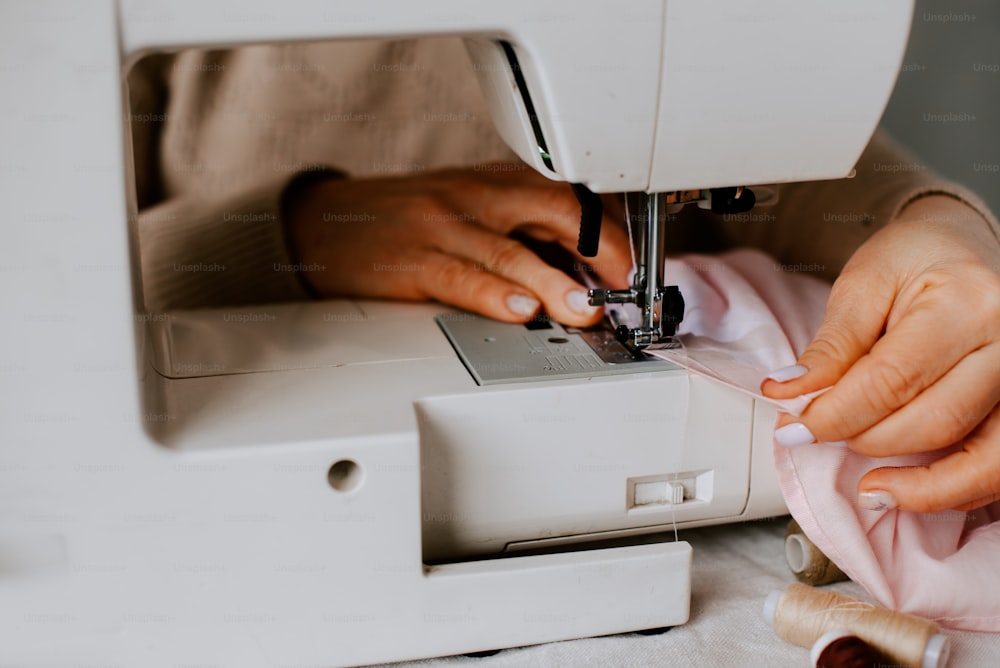uma mulher está usando uma máquina de costura para costurar