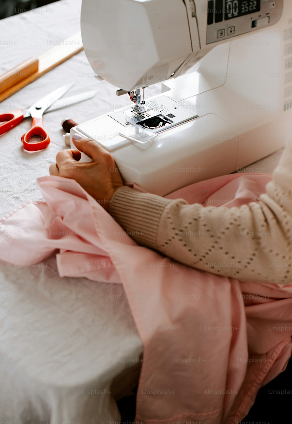 Una mujer usando una máquina de coser en una mesa