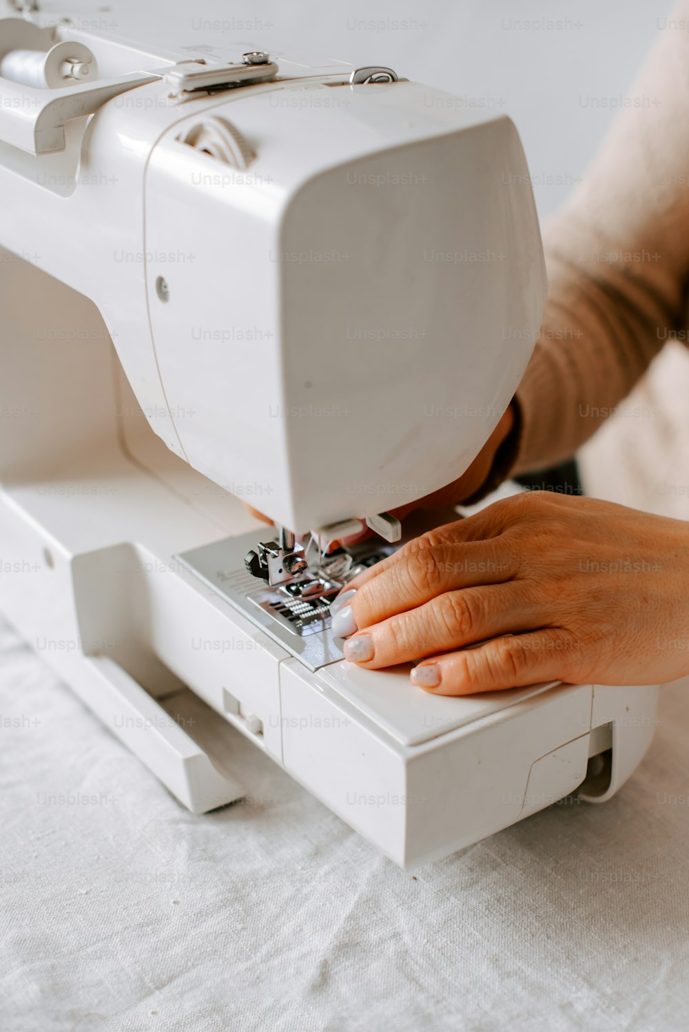 uma pessoa usando uma máquina de costura para costurar um pedaço de tecido