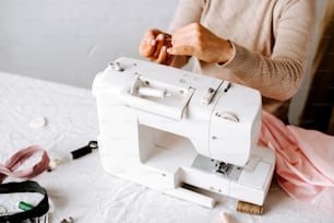 a woman using a sewing machine on a table