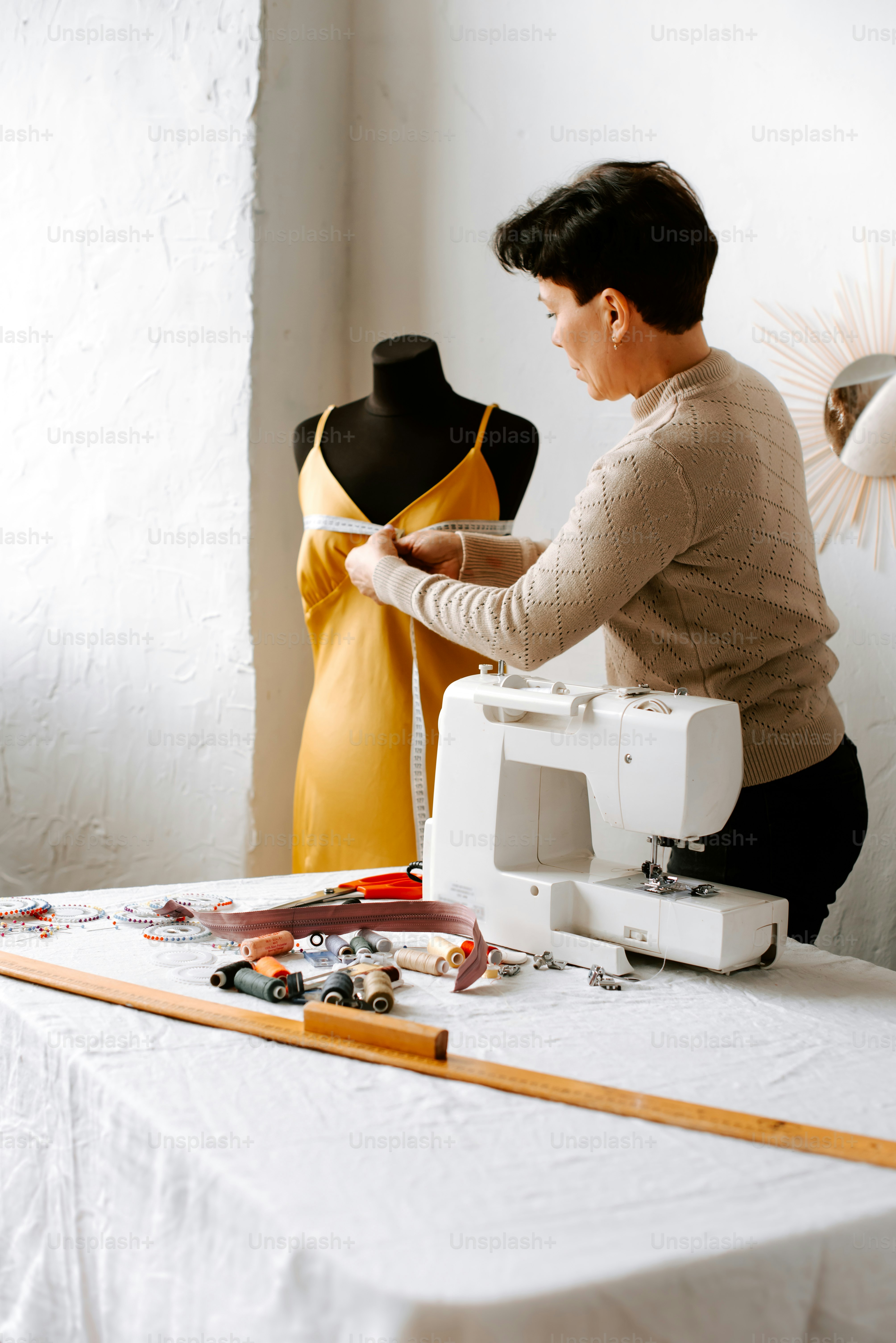 a woman using a sewing machine to sew a dress