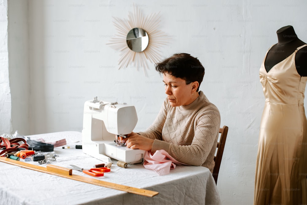 a woman sitting at a table working on a sewing machine