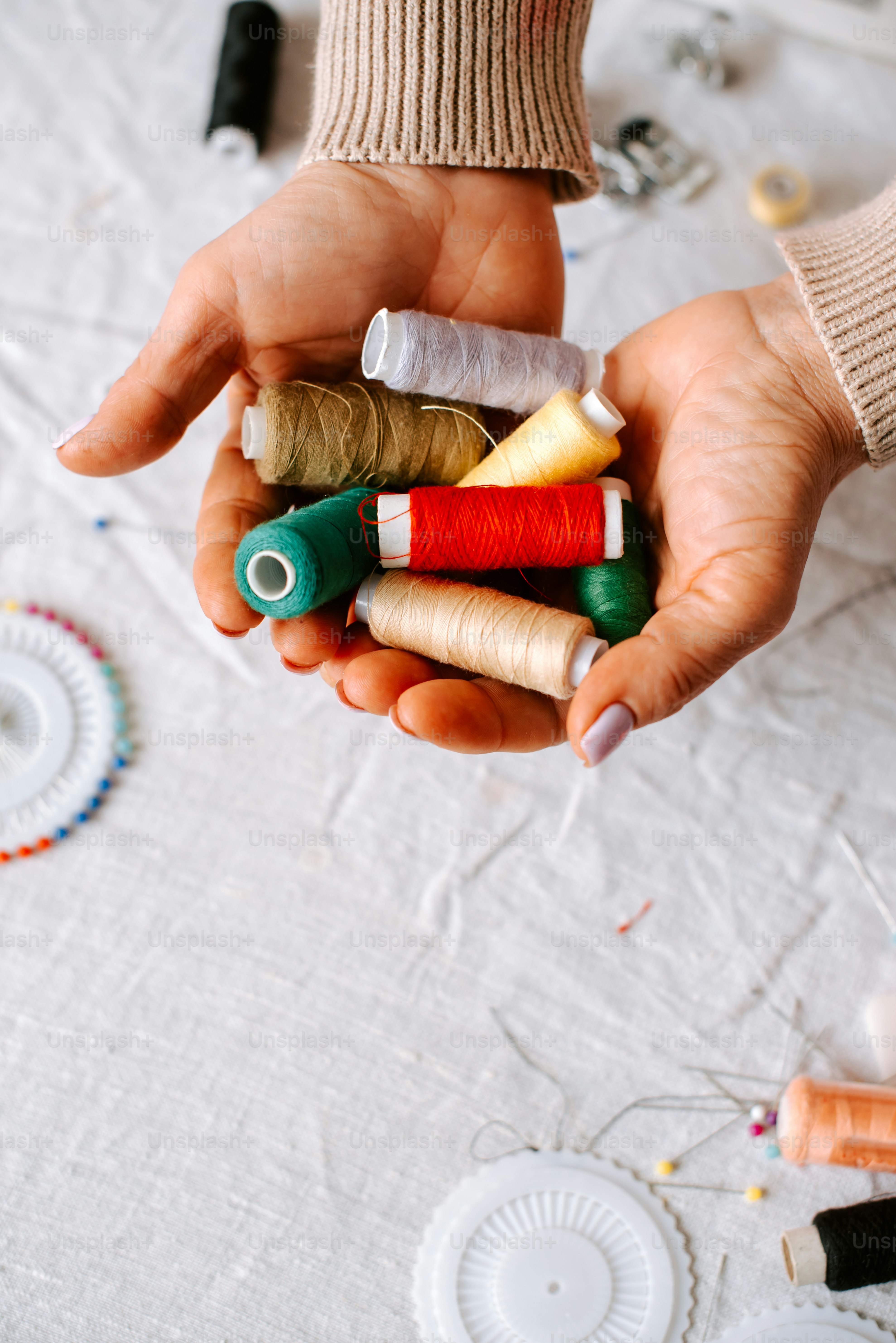 a person holding a bunch of spools of thread