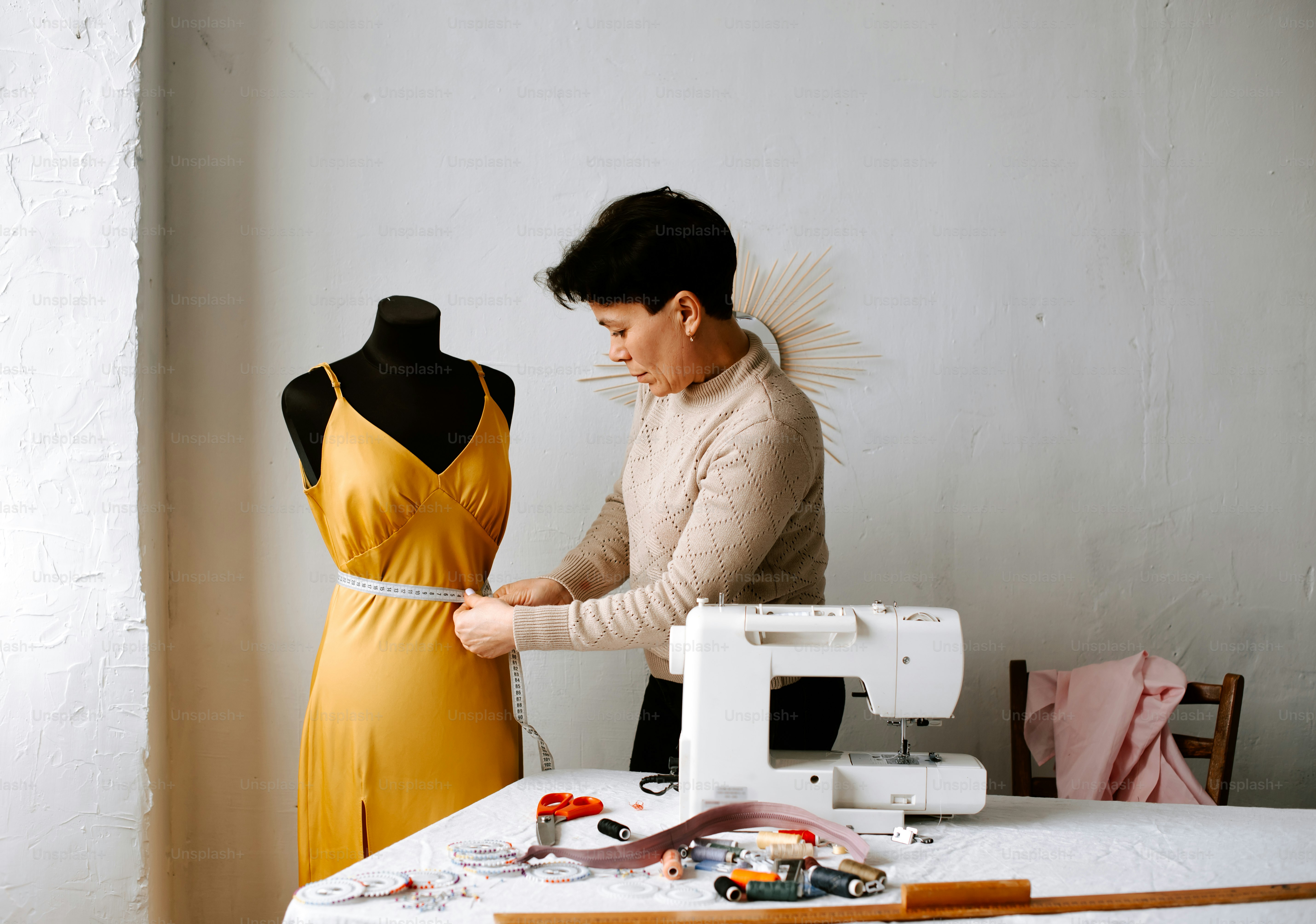 a woman working on a dress on a sewing machine