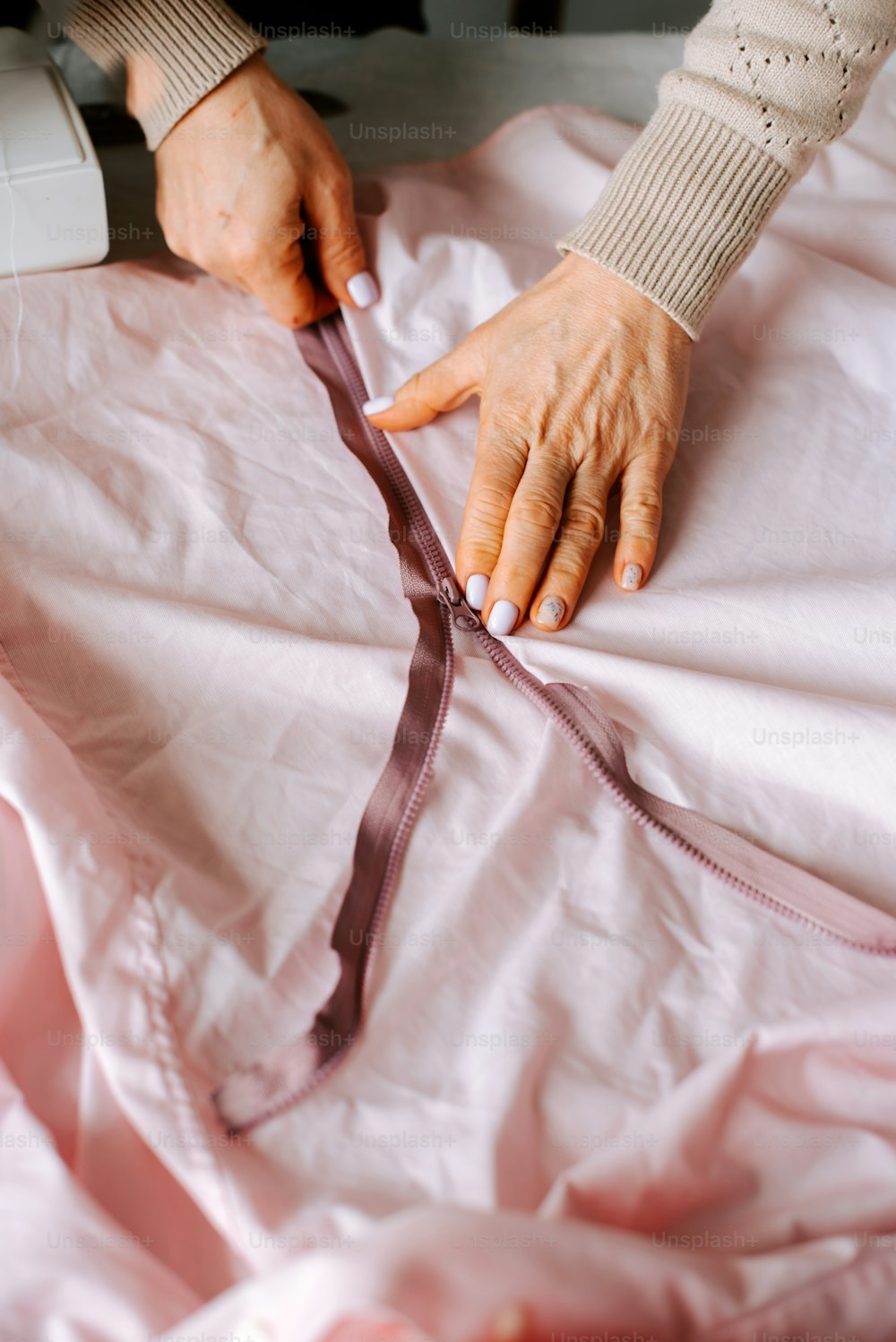 Les mains d’une femme sur un drap rose