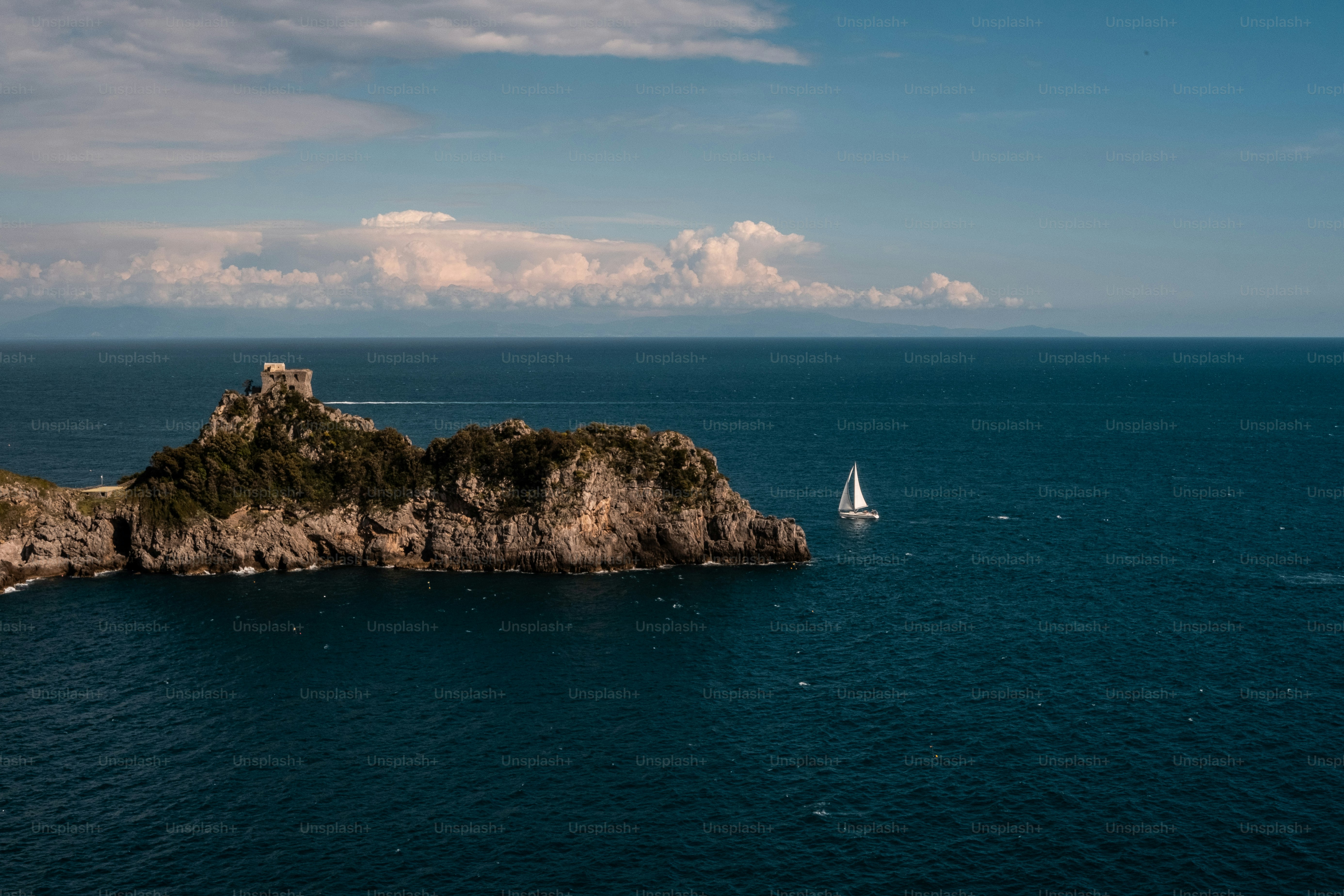 ein Segelboot im Ozean in der Nähe einer kleinen Insel