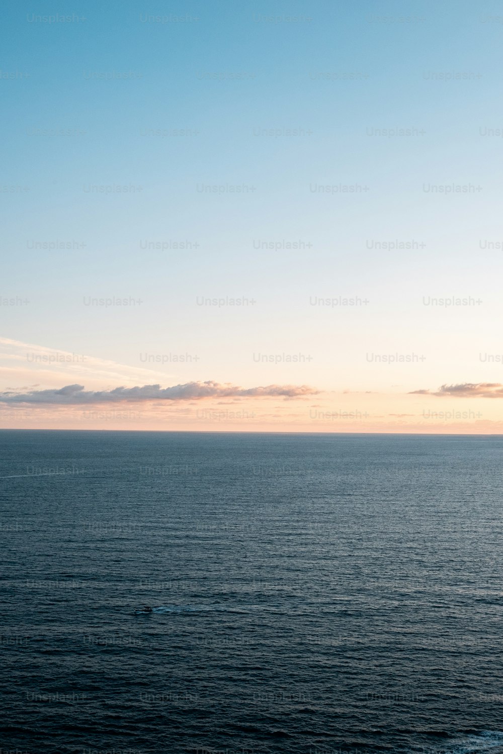 a large body of water sitting under a blue sky