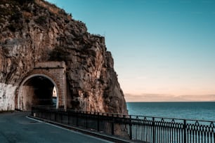 Une route qui pénètre dans un tunnel au bord de l’océan