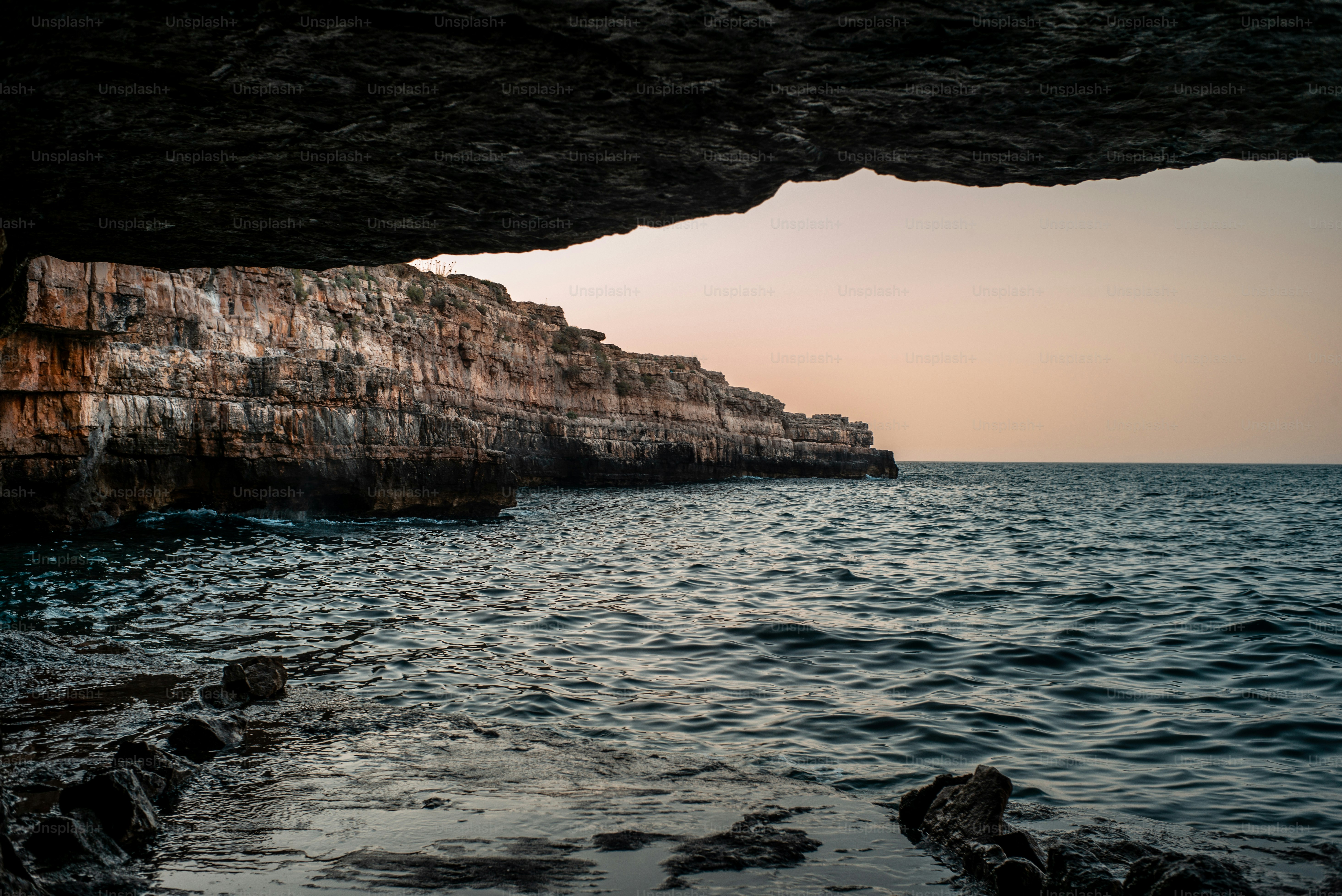 a large body of water next to a rocky cliff