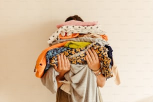 une femme portant une pile de vêtements sur son dos