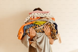 a woman carrying a pile of clothes on her back