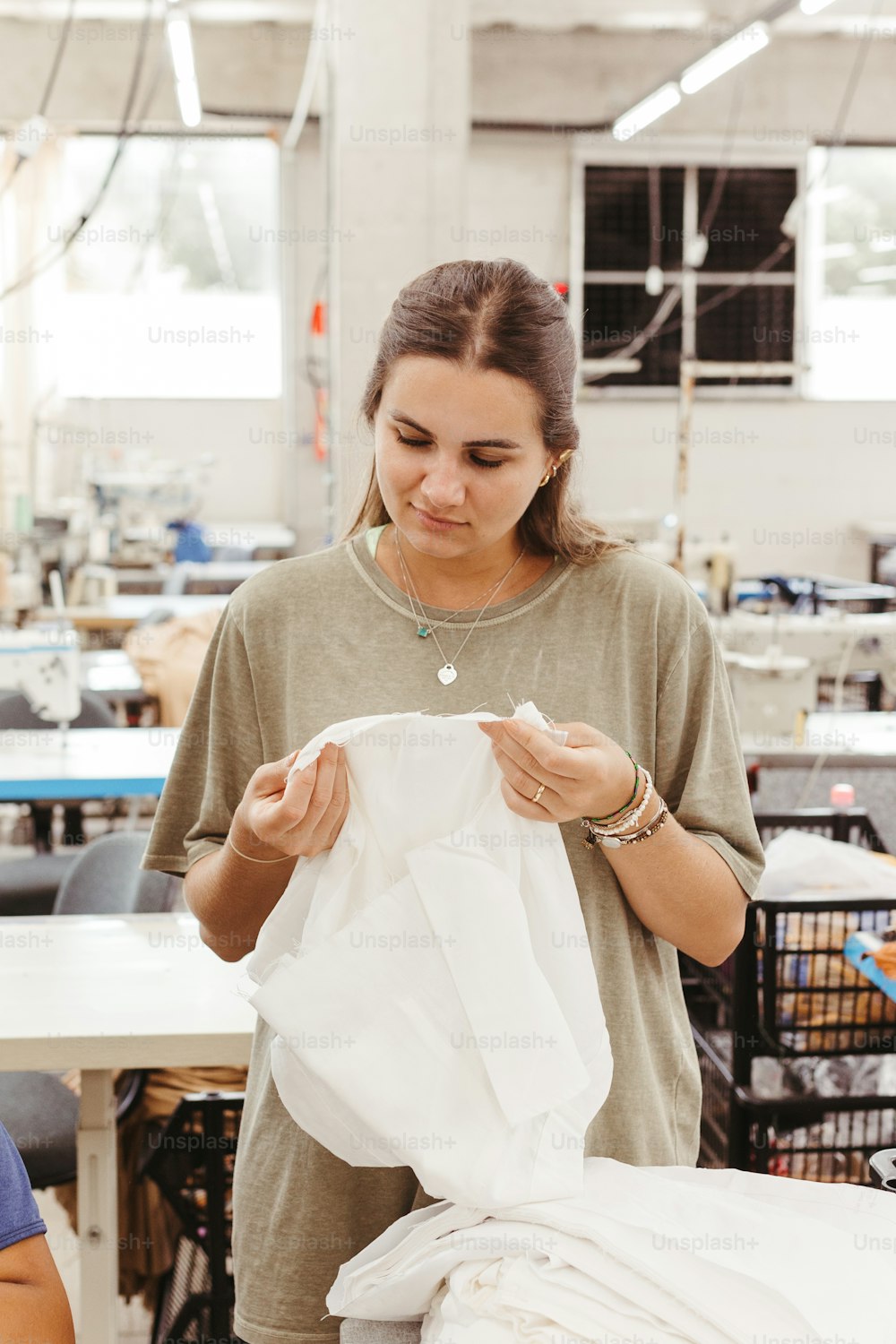 Una mujer en una fábrica trabajando en un trozo de tela
