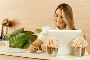 Eine Frau sitzt mit einem Laptop am Schreibtisch