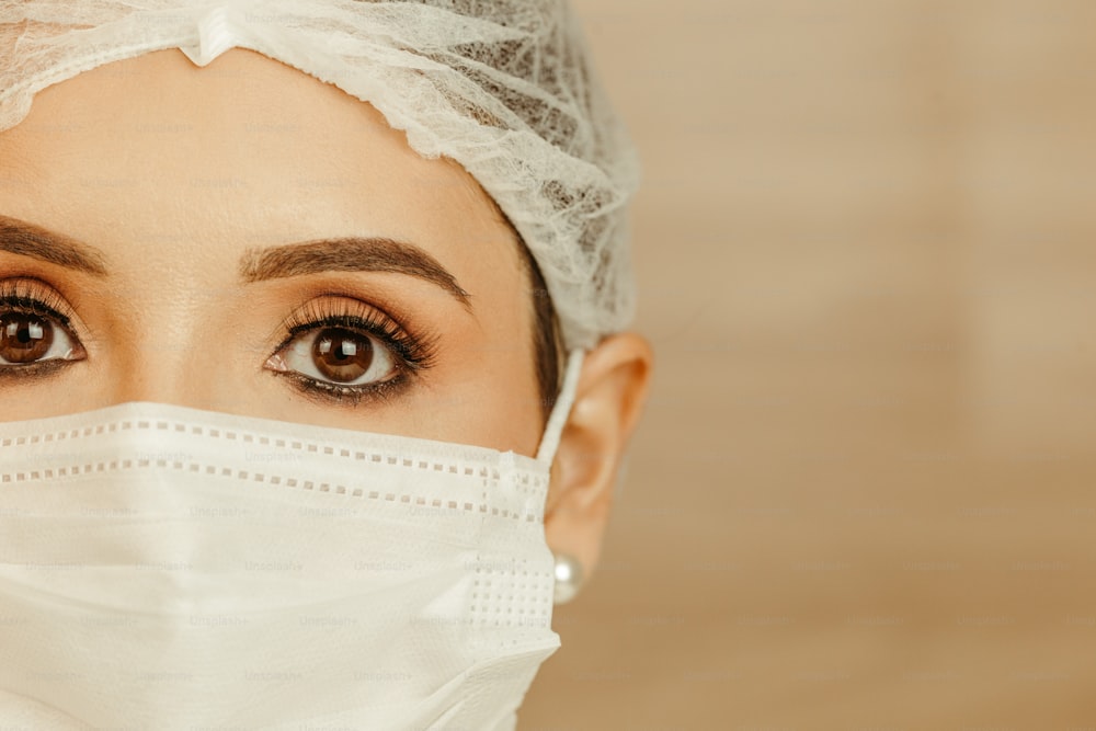 a woman wearing a surgical mask and a white cap