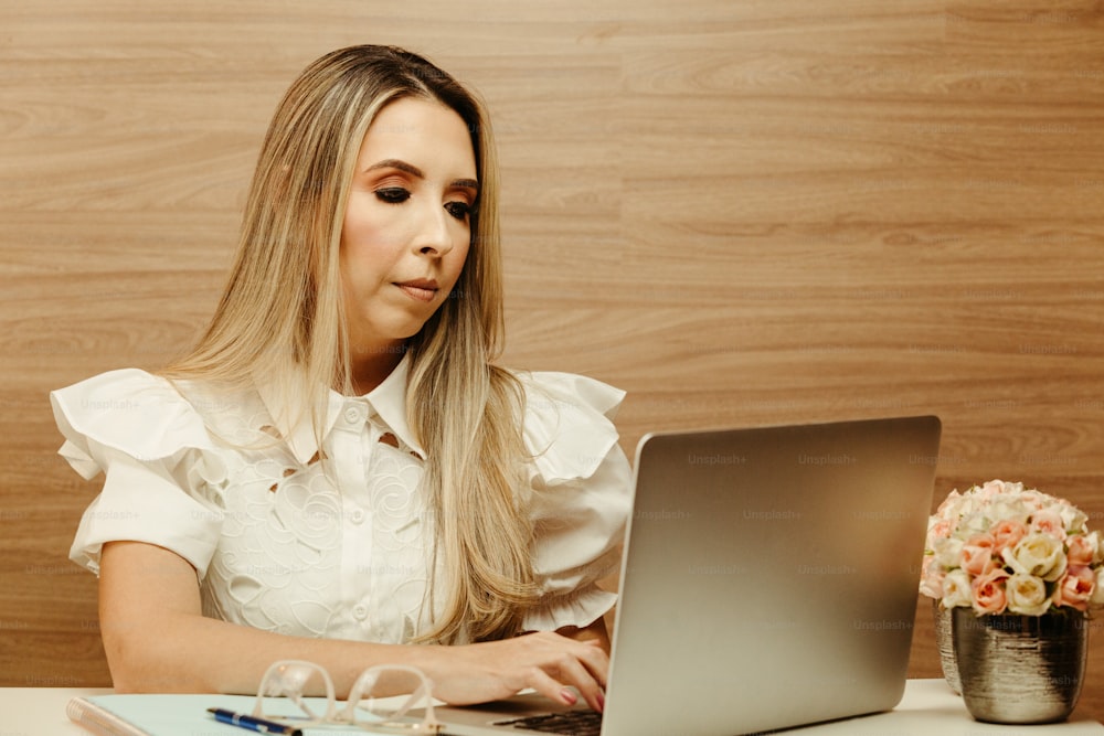 a woman sitting in front of a laptop computer