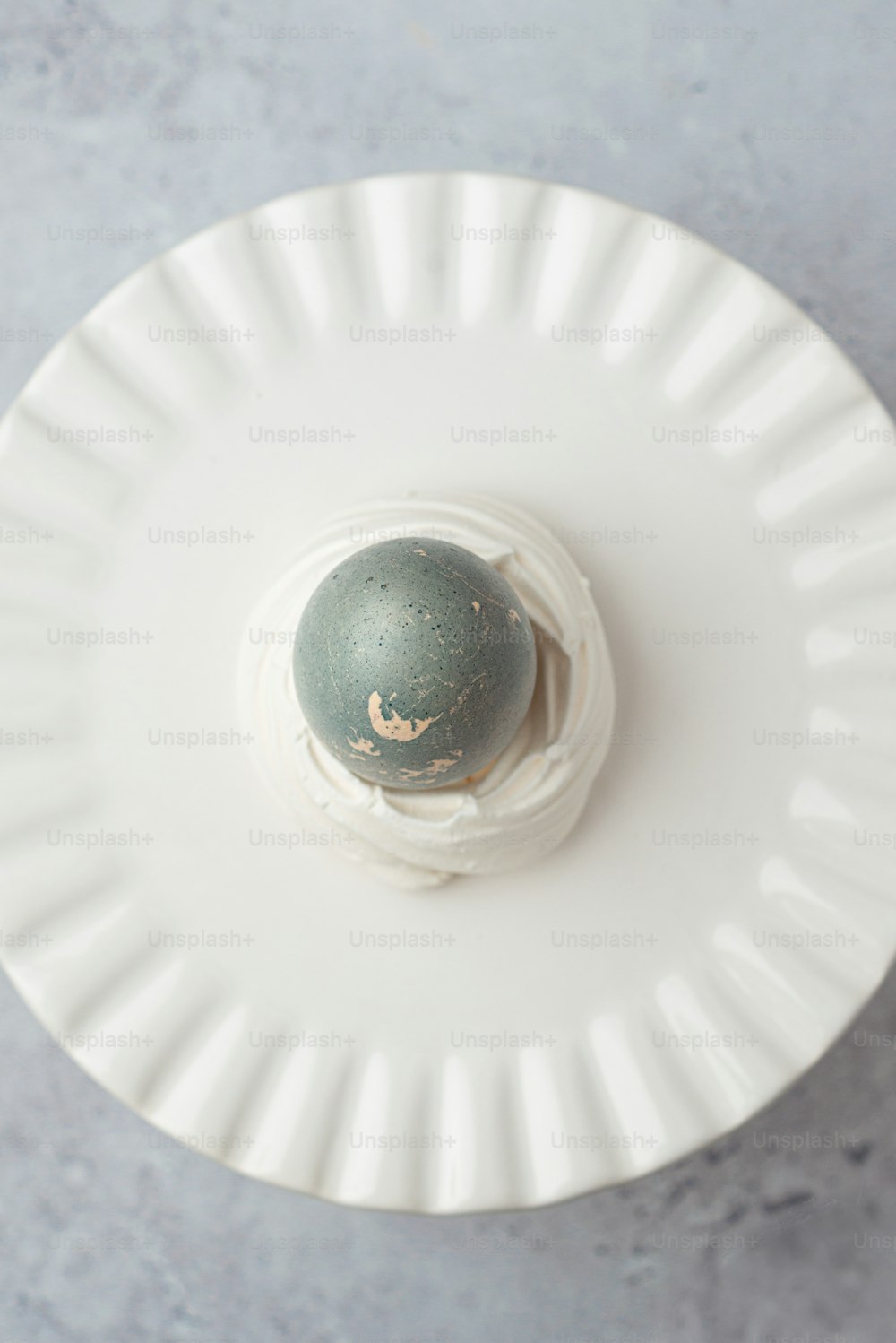 a white plate topped with an egg on top of a table