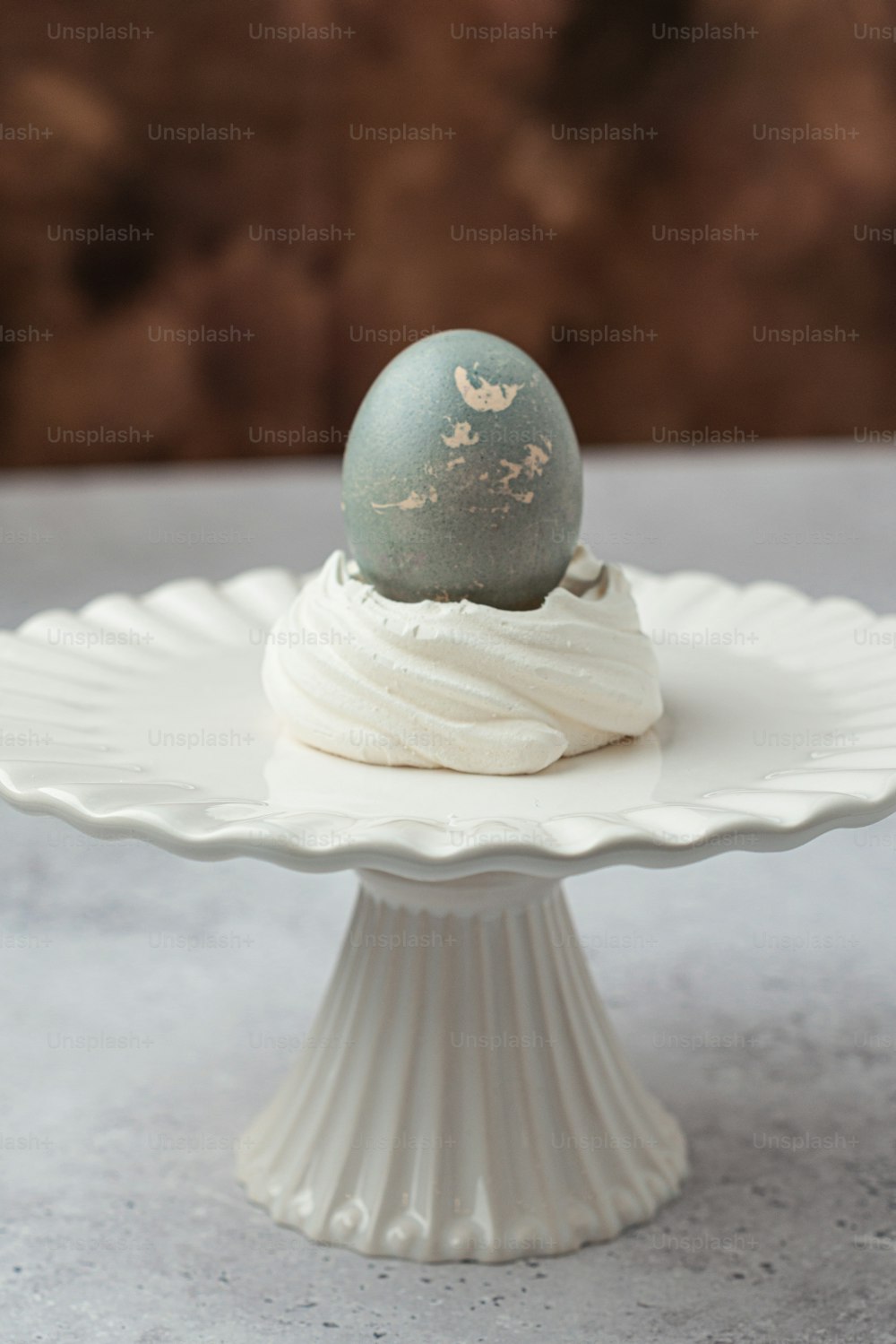 an egg sitting on top of a white cake plate