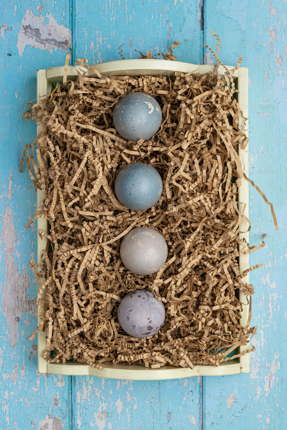 three eggs in a nest on a blue background