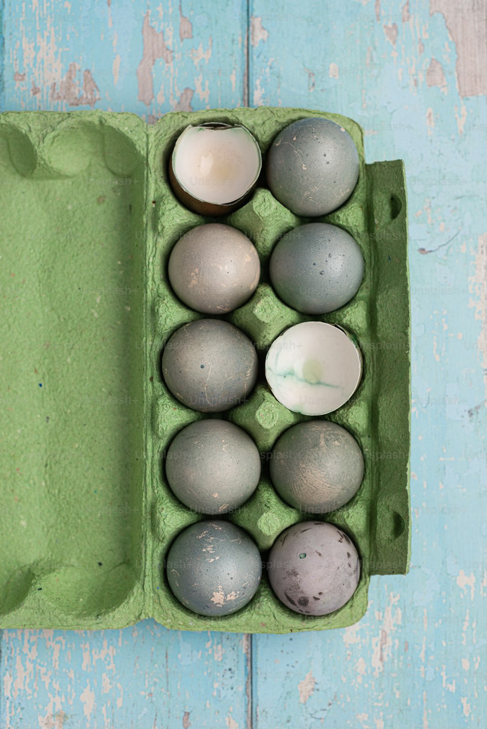 un cartón de huevos sobre una mesa de madera azul