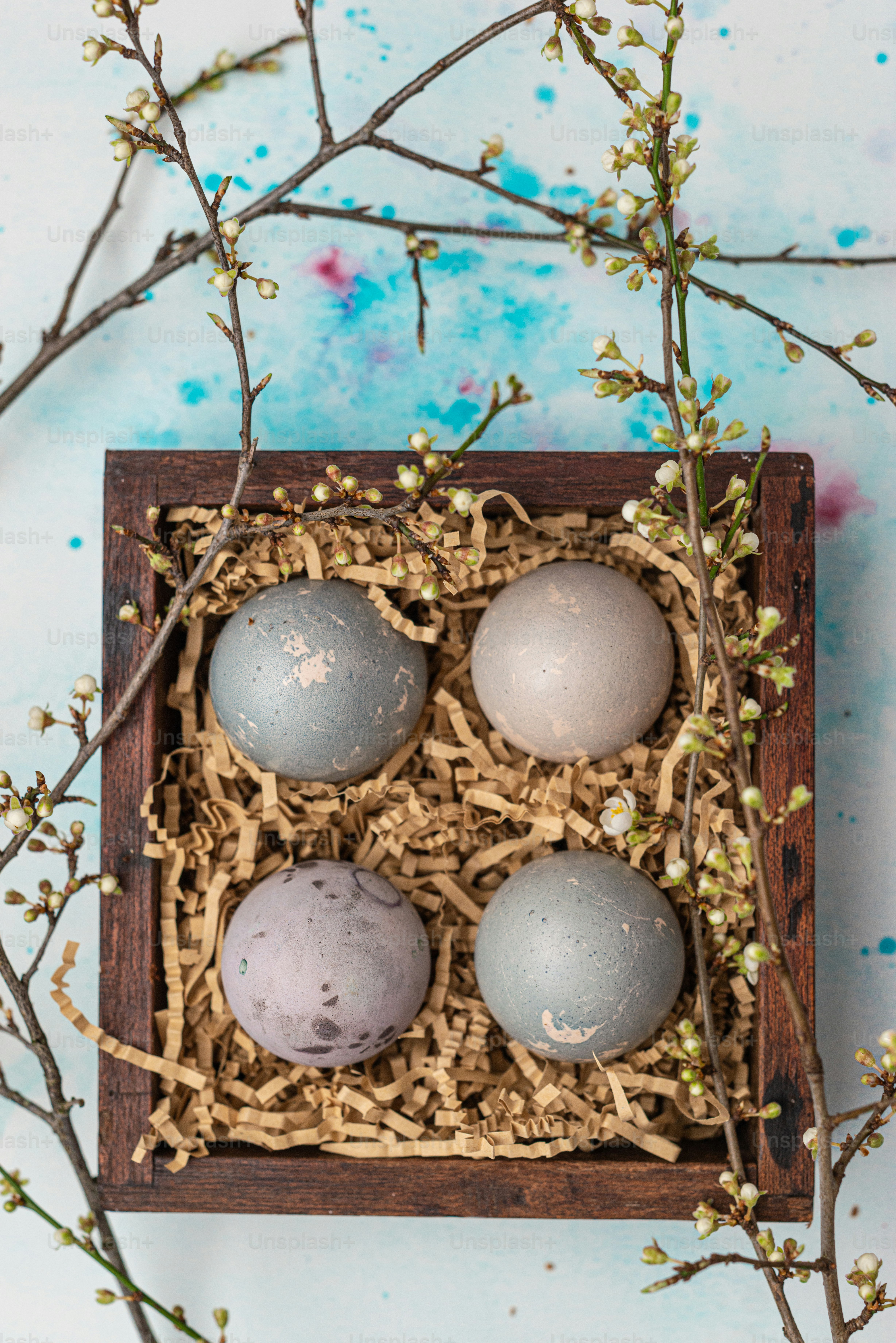 three eggs in a wooden box on a table