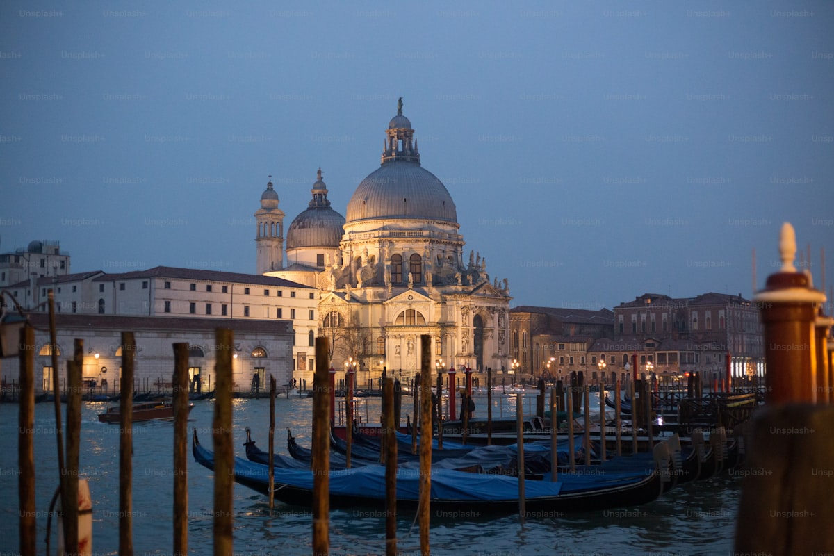 Gondolas moored in front of a grand Venetian palazzo at dusk