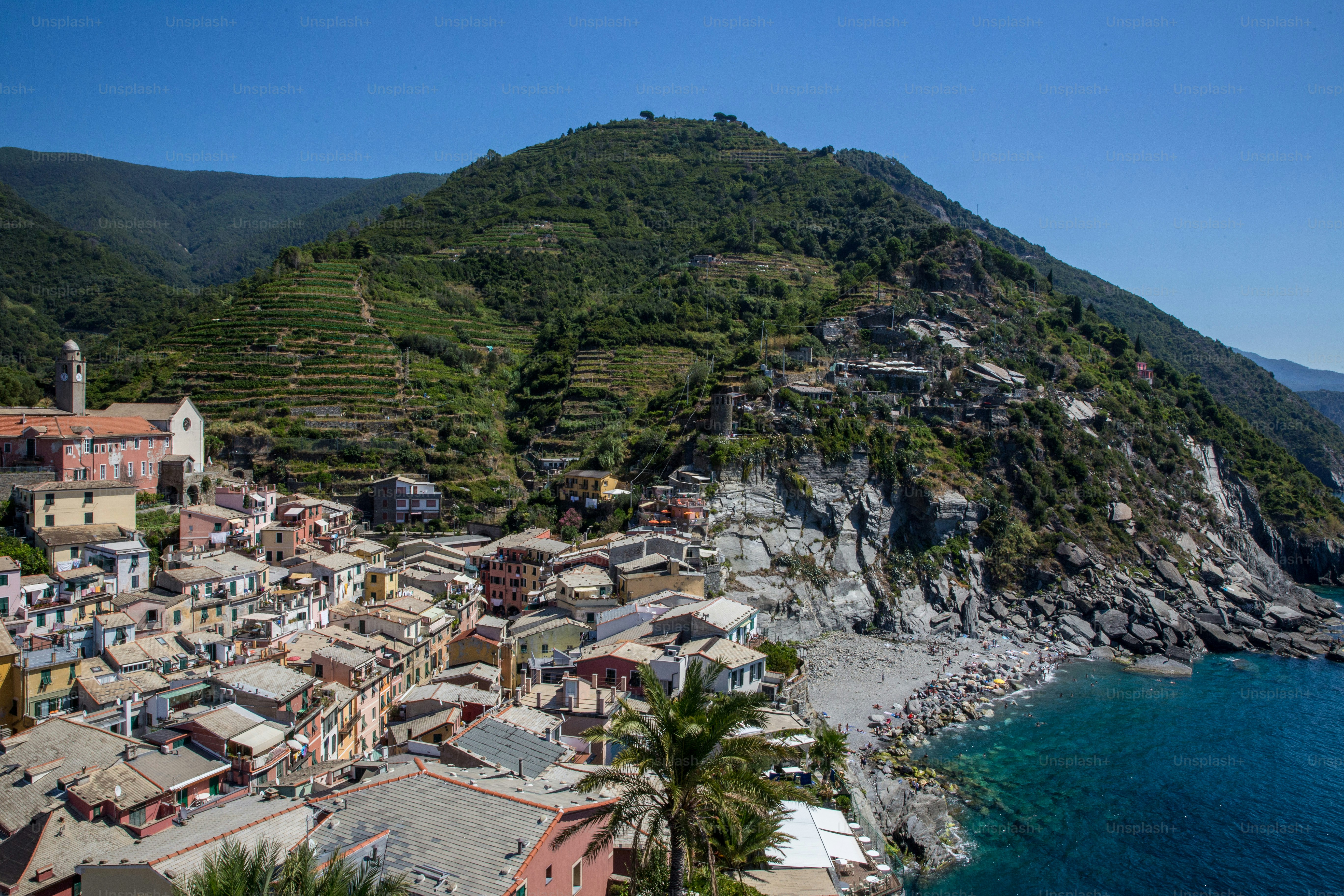 a small village on the side of a mountain next to a body of water